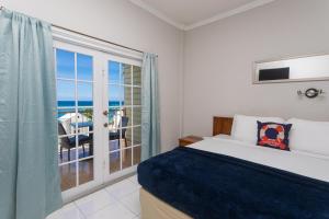a bedroom with a bed and a view of the ocean at Caribic House in Montego Bay