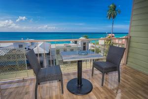 a table and chairs on a balcony with the ocean at Caribic House in Montego Bay