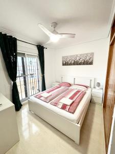 Habitación blanca con cama y ventana en Villa Dulce, en Gran Alacant