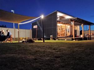 a building with people sitting in the grass at night at Cabaña / loft in Puerto Montt