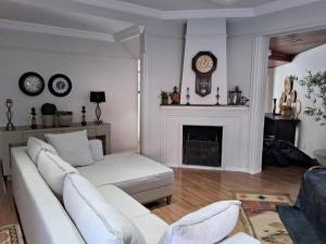 sala de estar con sofá blanco y chimenea en Casa com piscina, churrasqueira, fogão à lenha. SUL DE MINAS GERAIS, en Itajubá