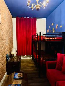 Cette chambre comprend 2 lits superposés et un rideau rouge. dans l'établissement Harry Potter expérience, à Marseille
