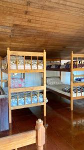 a room with three bunk beds in a cabin at Casa Lee Hostel in Paraty