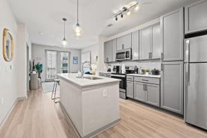 a kitchen with white cabinets and stainless steel appliances at Tropical Field 1 Bed in Downtown With FREE Parking in St Petersburg