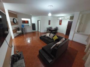 ein Wohnzimmer mit einem Sofa und einem Tisch in der Unterkunft Departamentos de la Costa in Machala