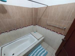 - Baño con bañera y toalla azul en Departamentos de la Costa, en Machala