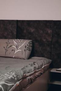 łóżko z poduszką z kwiatami w obiekcie Apartment Panorama Gjakove w mieście Gjakove