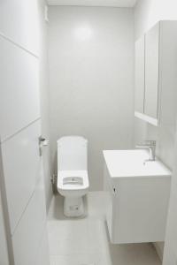 biała łazienka z toaletą i umywalką w obiekcie Apartment Panorama Gjakove w mieście Gjakove