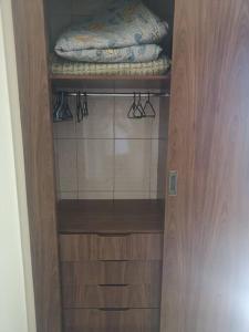 un armario con puerta de madera y una almohada en un estante en Apartamento próximo a praia, en Marataízes