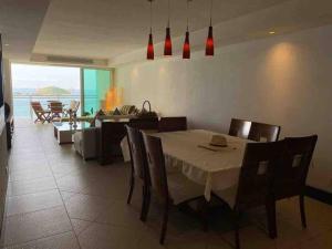 Un comedor y una sala de estar con mesa y sillas. en Relax and Enjoy, en Ixtapa