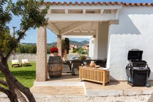 eine Terrasse mit einem Holztisch und einem Fass in der Unterkunft "Villa Adele" in Olbia
