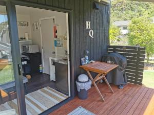 een patio met een tafel op een terras bij Pacific Bay HQ - Tutukākā Holiday Unit in Tutukaka