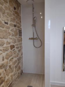 La salle de bains est pourvue d'une douche et d'un mur en pierre. dans l'établissement The Cow Byre - Cotswold retreat with hot tub, à Dursley