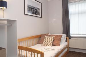 um berço num quarto com uma janela em Cosy 3 bed home with garden - near to uni, restaurants & bars em Hull