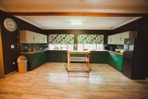 a kitchen with green cabinets and a table in it at I Stay @ De 22 On Vintage in Windhoek +20 photos