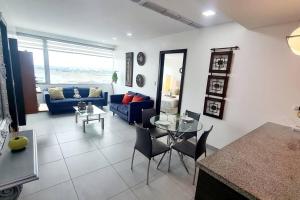 uma sala de estar com um sofá azul e uma mesa de vidro em Ecusuites Apartamento Ejecutivo Hotel Sheraton Aeropuerto Quo em Guayaquil