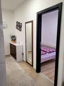 a room with a mirror and a bed with purple sheets at Apartman Lukić in Banja Koviljača