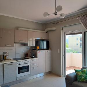 a kitchen with white cabinets and a stove top oven at Lefkada CP Residences in Lefkada Town