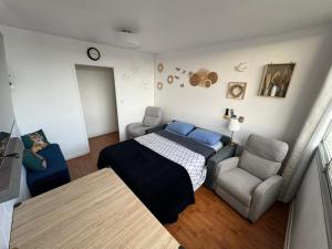 a bedroom with a bed and a couch and a chair at Private room in a shared apartment - Metro 7 and Tramway T3a in Paris