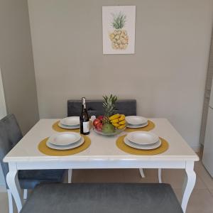 a table with two plates and a bowl of fruit at Lefkada CP Residences in Lefkada Town