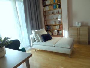 un soggiorno con divano bianco e libreria di Casa Iris a Székesfehérvár