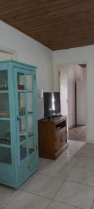 um quarto com um armário azul e uma televisão em Pousada Catalina em Florianópolis