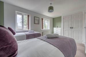sypialnia z 2 łóżkami i 2 oknami w obiekcie Beautiful 5 Bed House Free WIFI w Coventry