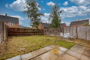a backyard with two chairs and a fence at Beautiful 5 Bed House Free WIFI in Coventry