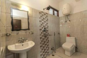 Hotel Ramida Suites At Delhi Airport في نيودلهي: حمام مع حوض ومرحاض