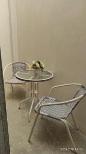 a table with two chairs and a table with flowers on it at La Casa de Joan in Máncora