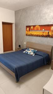 een slaapkamer met een bed met een blauw dekbed bij Santa Genoveffa Apartment in Trapani