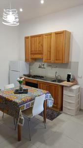 kuchnia ze stołem, krzesłami i zlewem w obiekcie Santa Genoveffa Apartment w Trapani