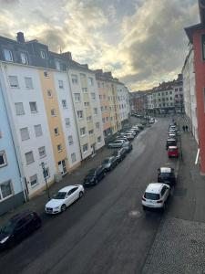 a group of cars parked on a street with buildings at Modernes Apartment Saarbrücken in Saarbrücken