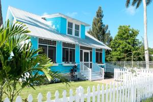 ein blaues Haus mit einem weißen Zaun davor in der Unterkunft Old Colorado Inn in Stuart