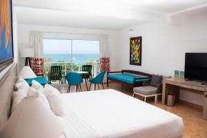 Royal Decameron Panama All Inclusive Plus في بلايا بلانكا: غرفة نوم مع سرير وغرفة معيشة