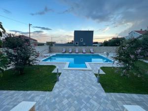 a swimming pool with chairs in a yard at Villa Maci in Kaštela
