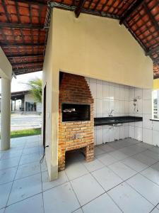 a kitchen with a brick fireplace in a building at Casa de praia Luís Correia in Luis Correia