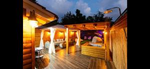 a wooden deck with a pergola at night at Private Garden House in Haifa