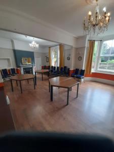duży pokój ze stołami i krzesłami oraz żyrandolem w obiekcie The Bank House Hotel w mieście Uttoxeter