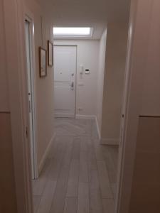 einen Flur mit weißer Tür und Fliesenboden in der Unterkunft Cristina in Sanremo
