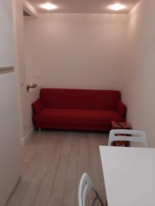 ein Wohnzimmer mit einer roten Couch in einem Zimmer in der Unterkunft Cristina in Sanremo