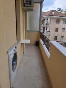 einen Balkon mit einer Waschmaschine und einem Fenster in der Unterkunft Cristina in Sanremo