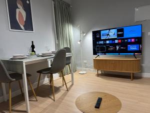 un soggiorno con tavolo e TV a schermo piatto di Dream SOROLLA a Santa Cruz de Tenerife