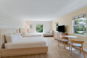 a hotel room with a bed and a table and chairs at Fisher Inn Resort & Marina in Islamorada