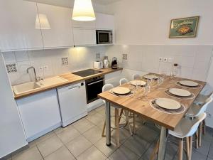 a kitchen with a wooden table and white appliances at Appart Cosy 6 personnes in Floirac