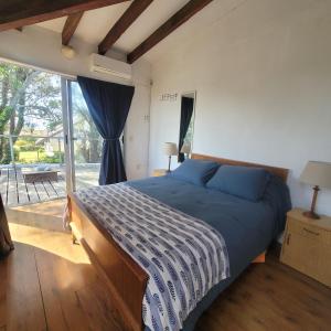 ein Schlafzimmer mit einem Bett und einem großen Fenster in der Unterkunft Casa Encantada Guest House in La Aguada