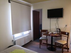 una camera d'albergo con scrivania, letto e TV di Los Lagos Hotel a El Calafate