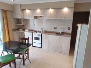 a kitchen with a table and a stove top oven at LOS Teros dptos 3 5 3 4 0 9 2 8 1 5 in Villa María