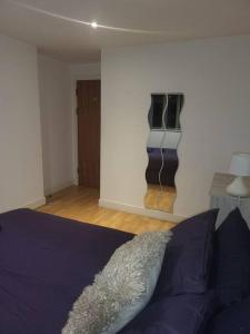a bedroom with a bed and a wall with a mirror at Striking 1 bedroom apartment in Manchester