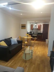 a living room with a couch and a table at Striking 1 bedroom apartment in Manchester